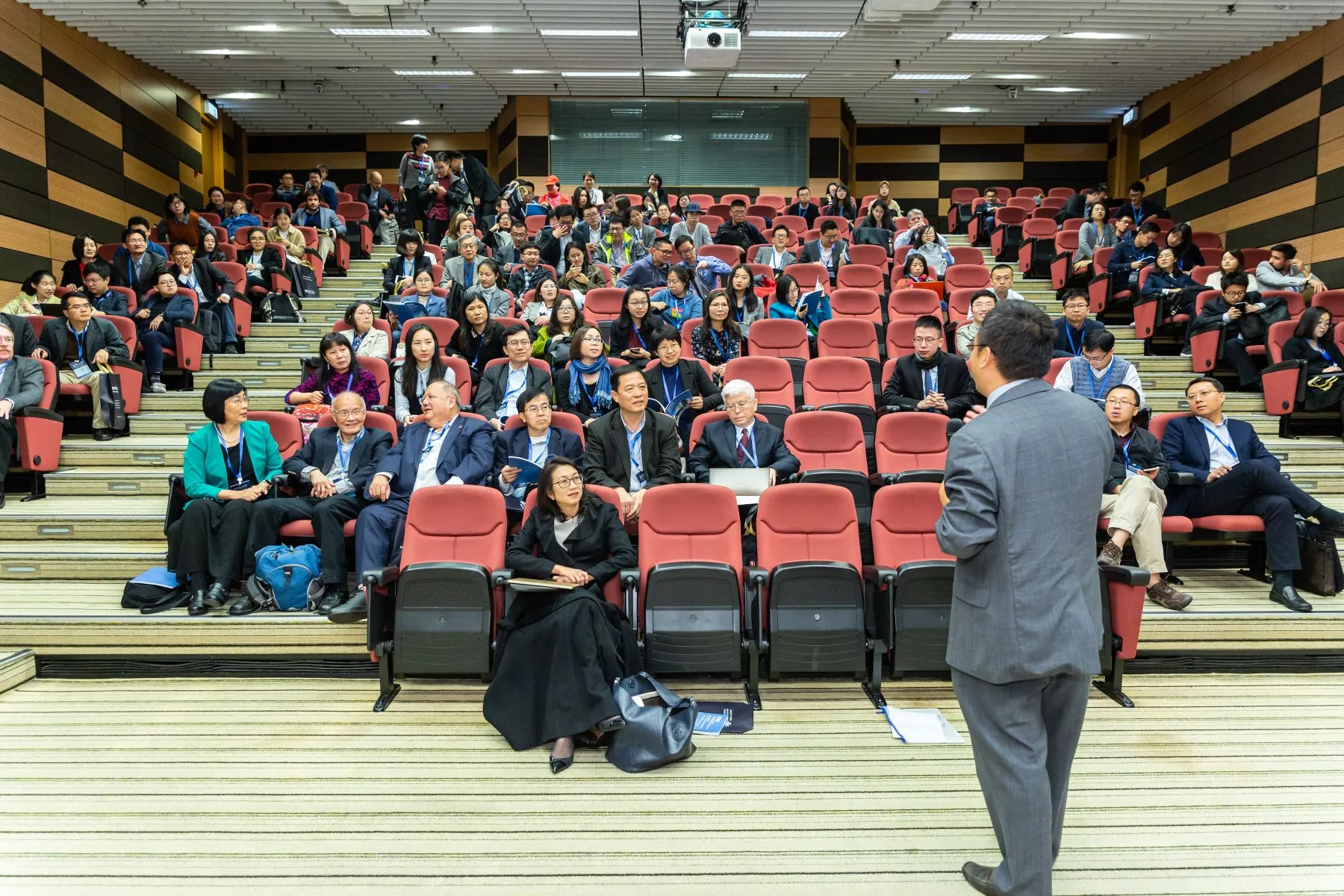 Conference attendees seated in an auditorium before a presentation