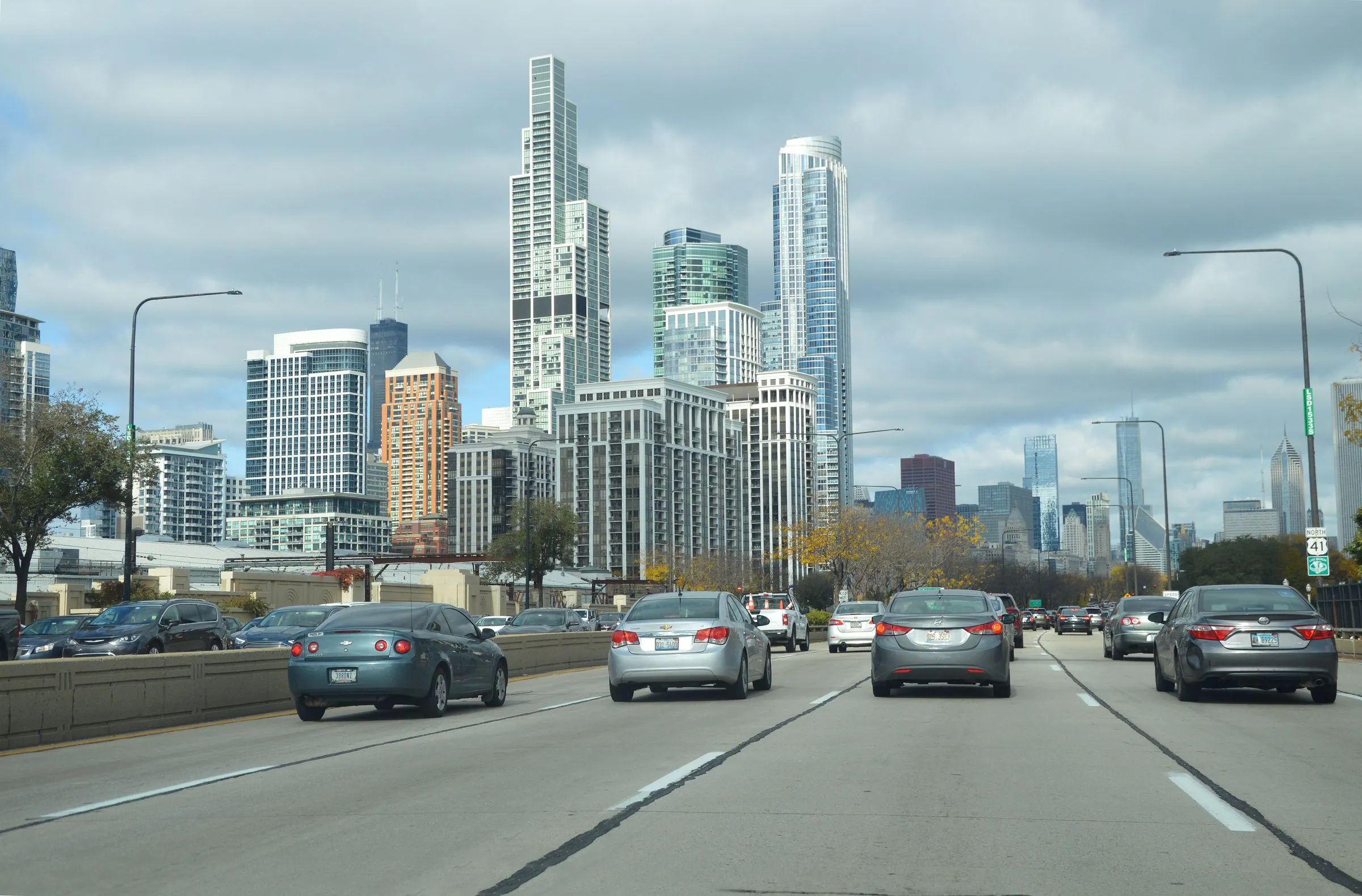 Traffic heading north on Lake Shore Drive toward the Chicago skyline on an overcast afternoon