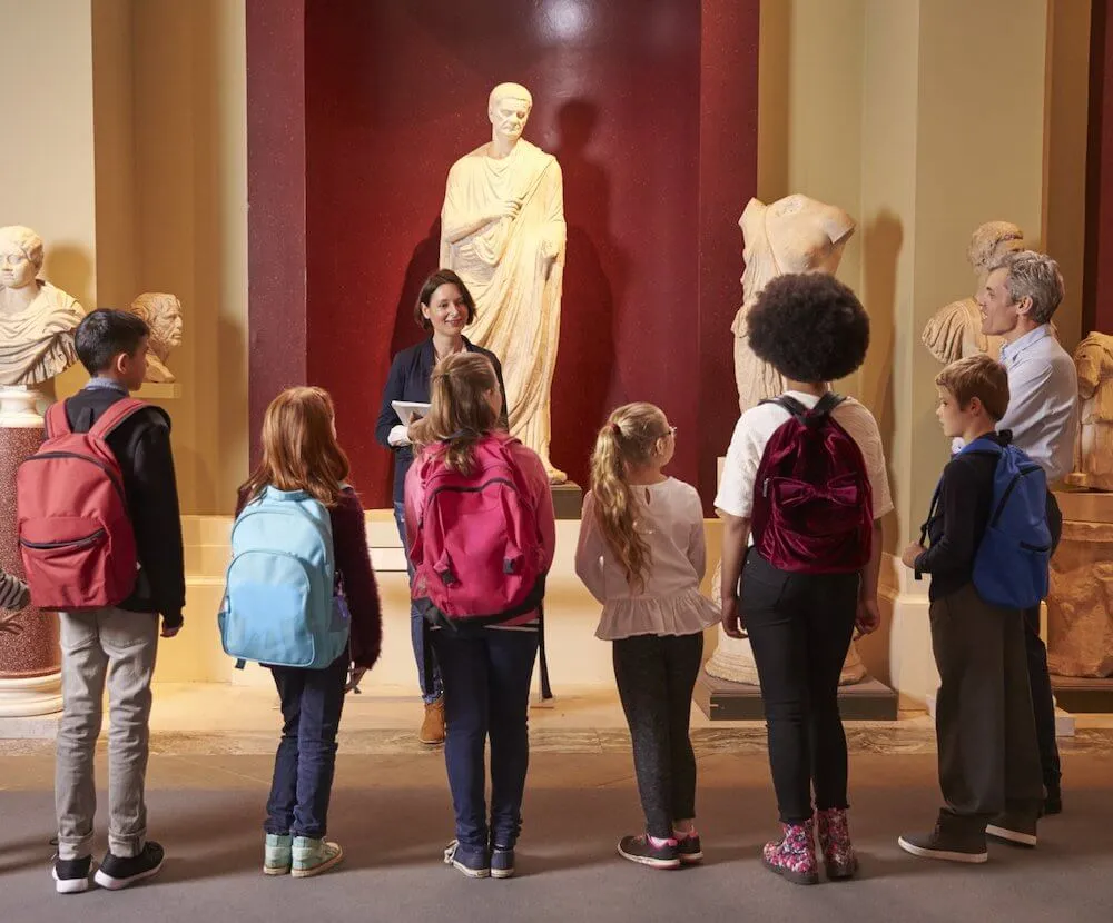 A school group listening to a teacher during a museum field trip